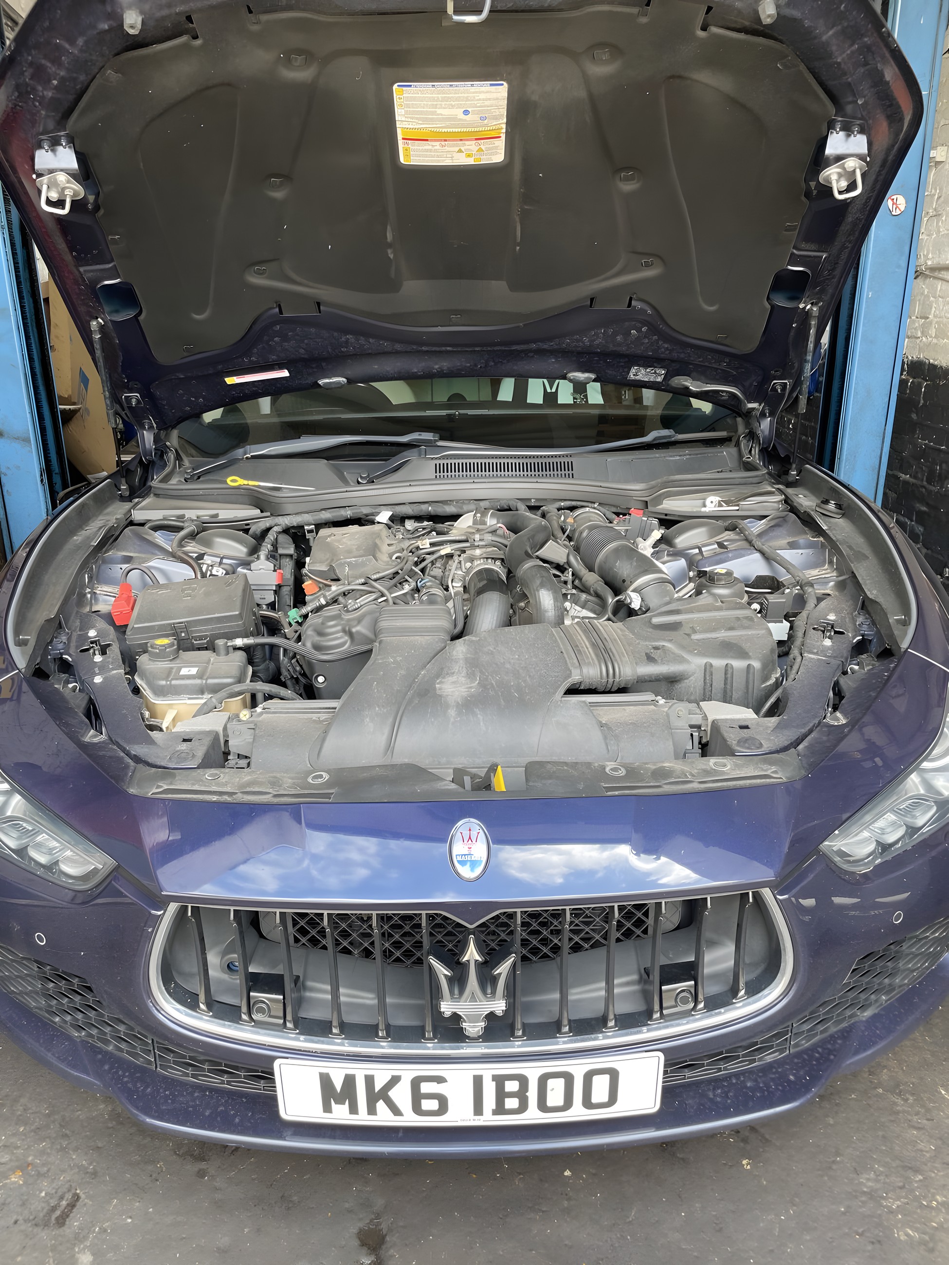 Engine bay open on a car being diagnosed at Lucky Garage