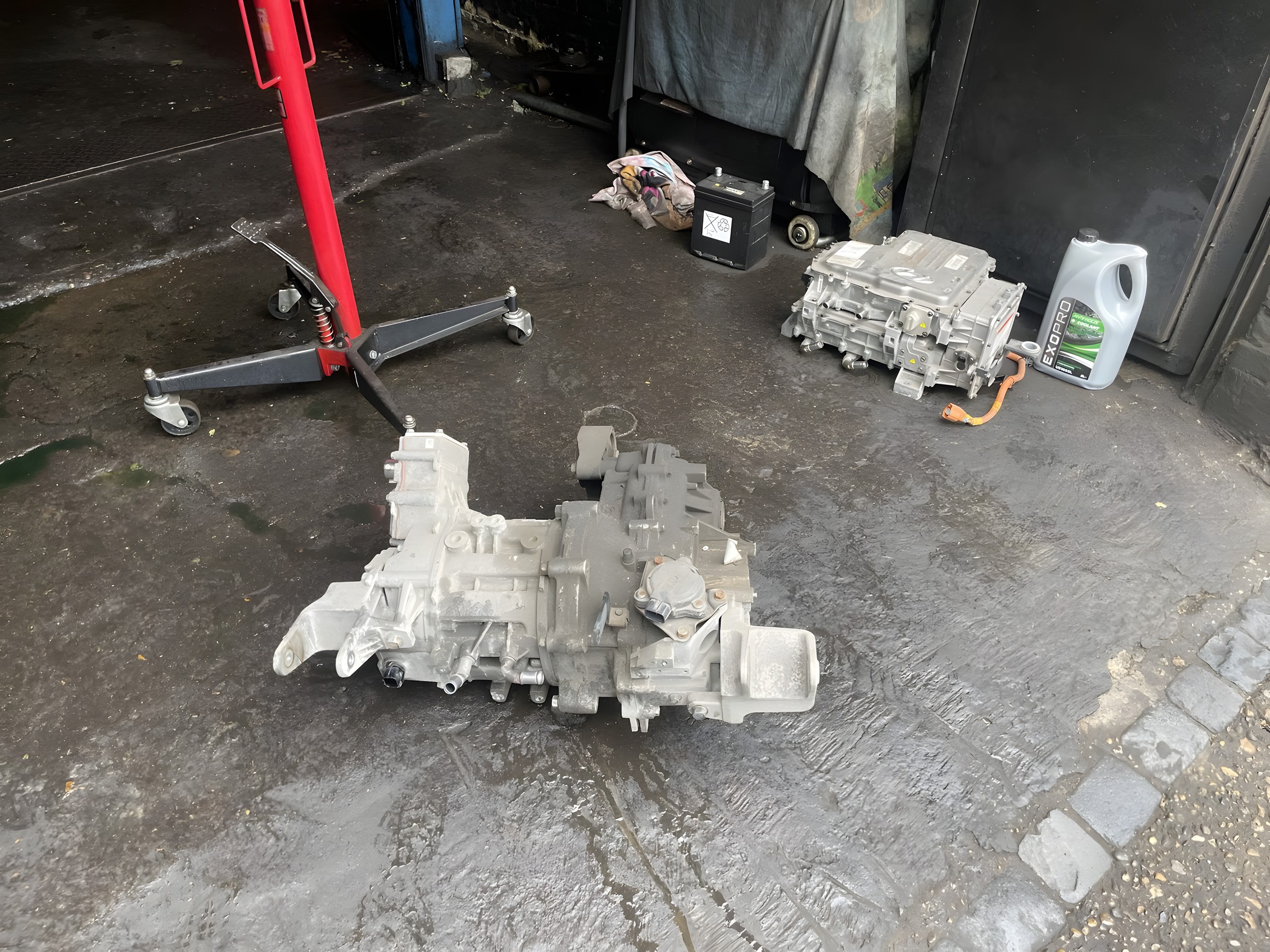 Gearbox and mechanical parts on the floor of the workshop at Lucky Garage